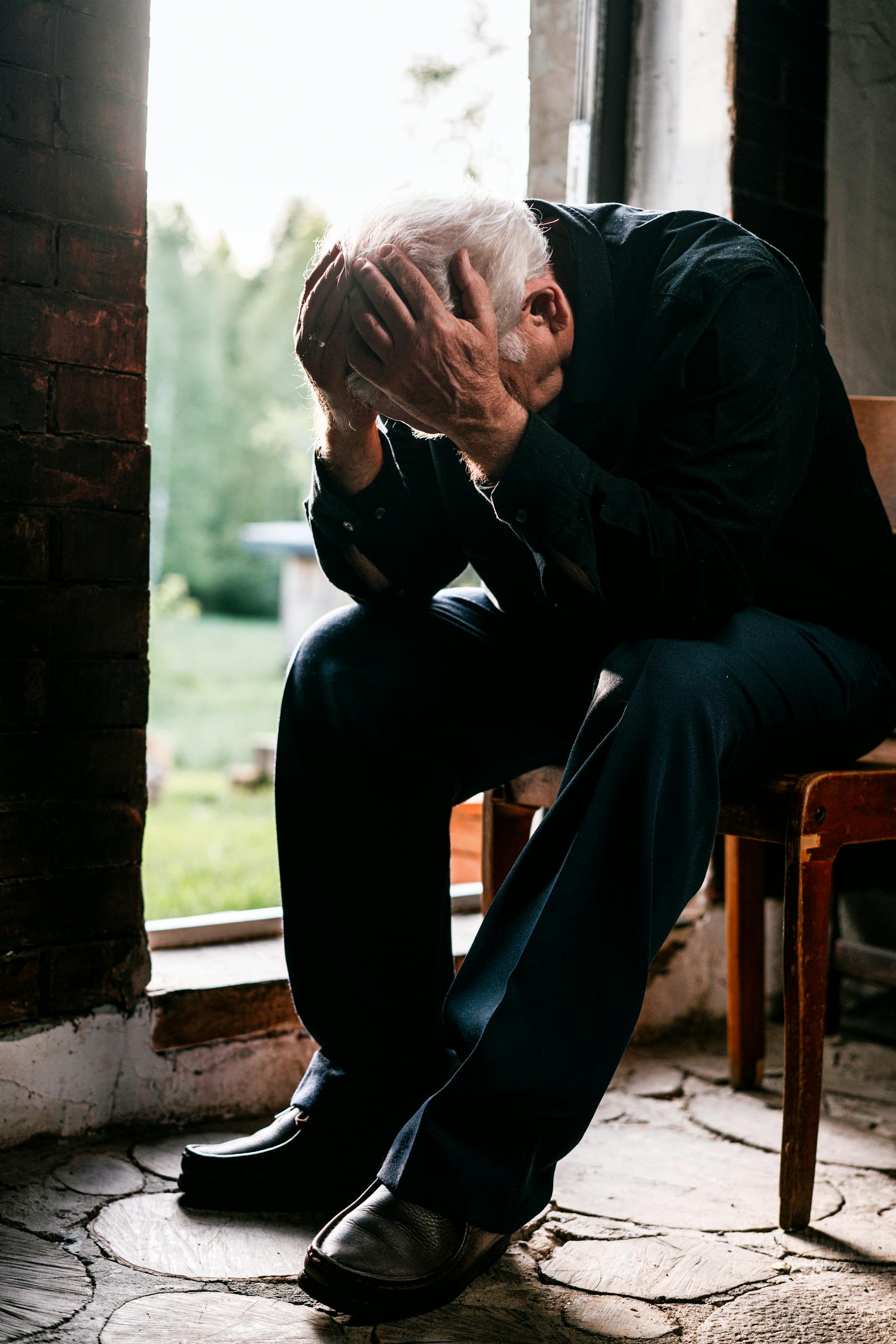 Man Sitting on Brown Woden Chair